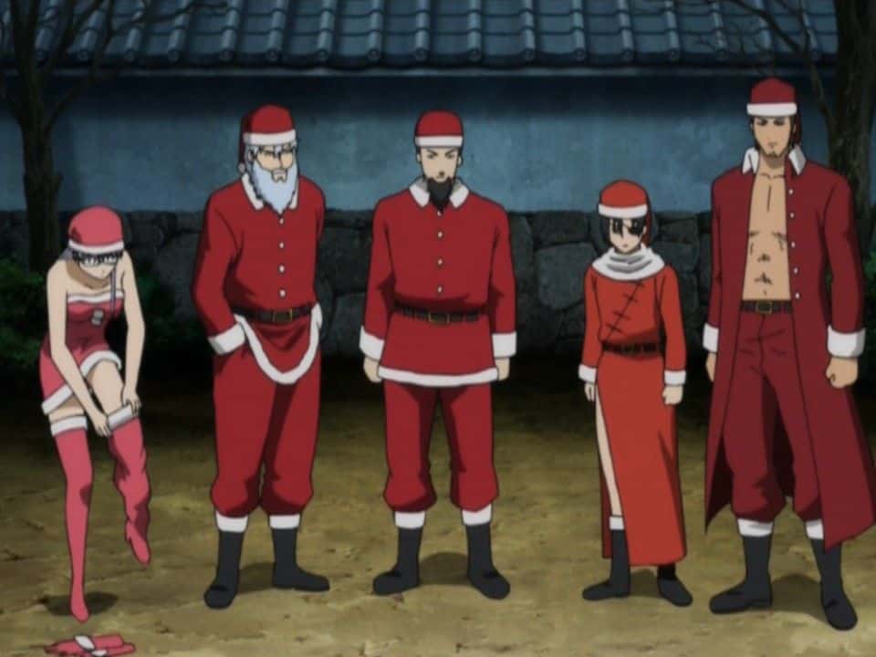 Fünf Anime-Figuren stehen in Weihnachtsmannkostümen im Freien; vier tragen klassische rote Anzüge, während die fünfte, links, ein rosa Weihnachtsmann-Outfit trägt und ihren Schuh zurechtrückt. Es wirkt wie ein lustiger Anime-Weihnachtsepisoden-Moment, als sie alle zusammen posieren.