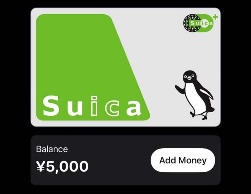 Eine digitale IC-Card Suica mit einem grün-weißen Design und einem Pinguin-Maskottchen wird angezeigt. Der Kontostand zeigt ¥5.000 an, daneben befindet sich eine Schaltfläche "Geld hinzufügen".