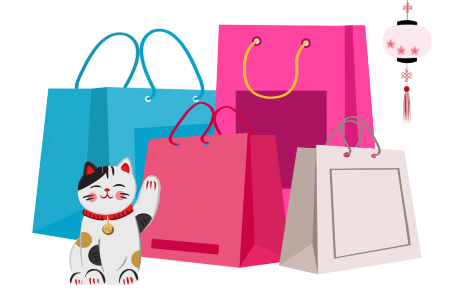 Eine winkende Glückskatze sitzt neben bunten Einkaufstüten in Blau, Rosa, Rot und Beige, die an Fukubukuro erinnern. Eine dekorative rosafarbene Laterne mit Blumenmustern hängt am rechten Rand des Bildes.