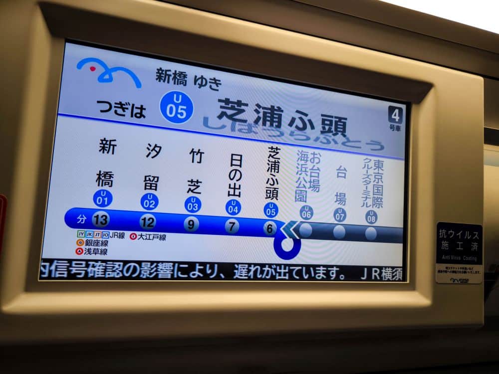 Ein digitales Zugdisplay in japanischer Sprache zeigt die Route, die Haltestellen und die Fahrzeiten für die Linie U05 nach Shibaura-futou in der Nähe von Odaiba an. Die Oberfläche ist in den Farben Blau, Weiß und Grau gehalten und enthält sowohl Text als auch Symbole.
