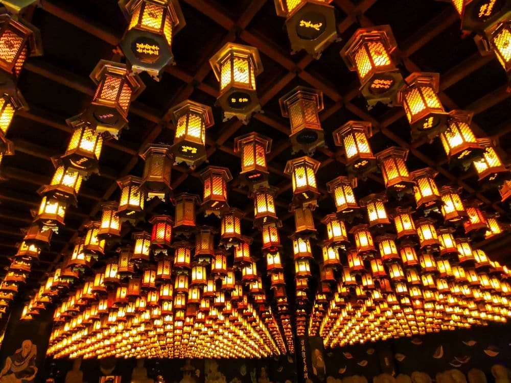 Die Decke ist mit Reihen von leuchtenden, verzierten Laternen bedeckt, die von Daishoin inspiriert sind und mit ihren komplizierten Mustern und ihrer symmetrischen Anordnung ein warmes, goldenes Ambiente schaffen.