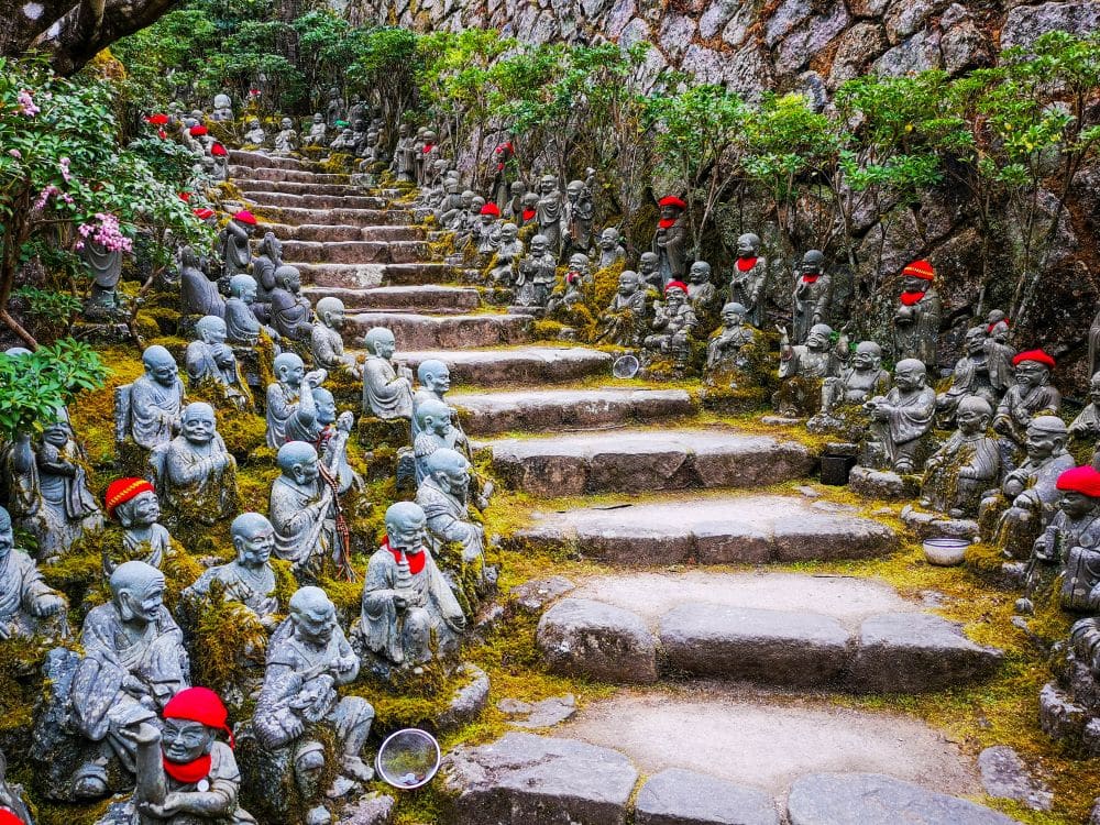 Eine Gruppe von Statuen auf der Daishoin-Treppe schafft eine ruhige und spirituelle Atmosphäre.